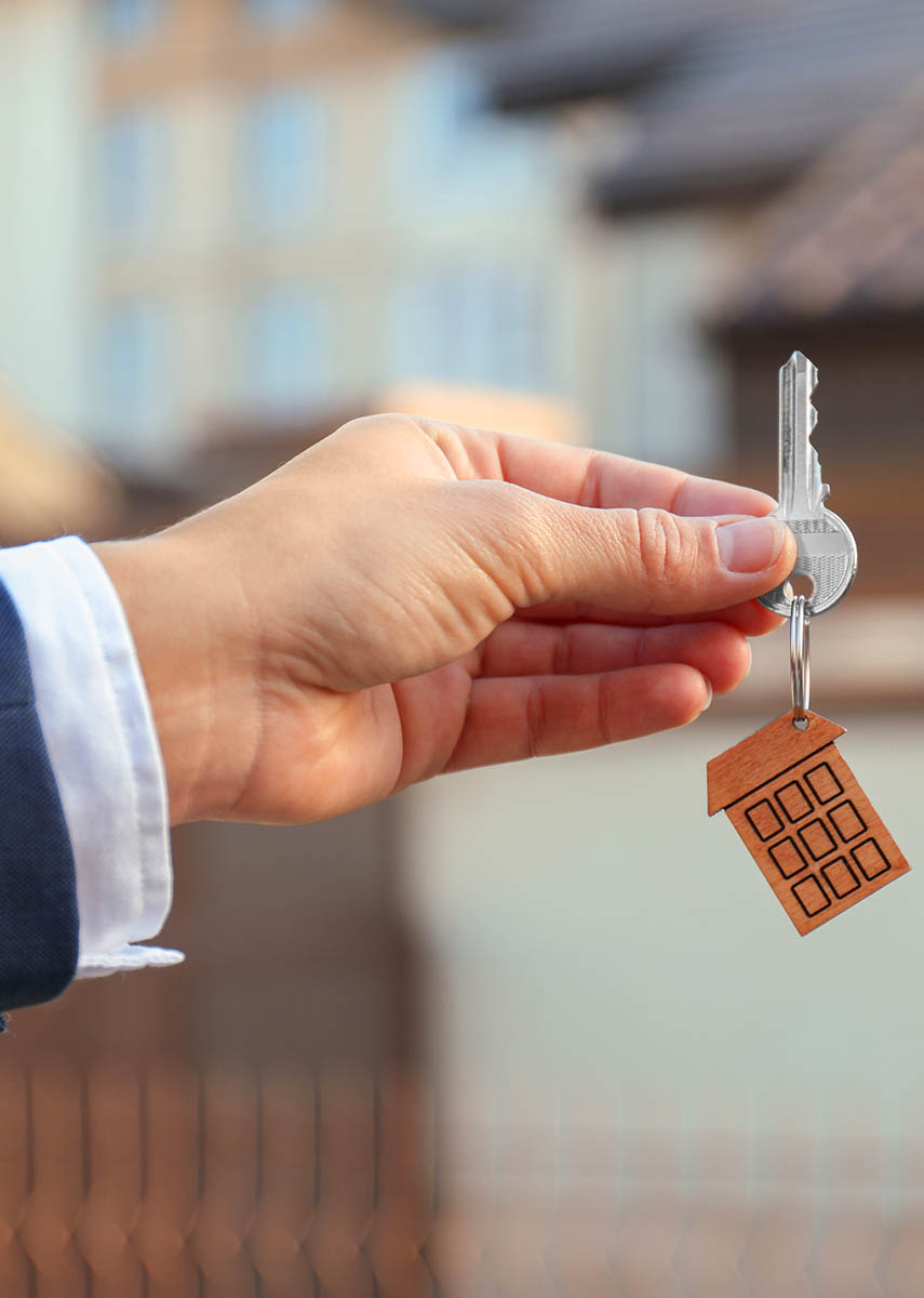 Real estate agent handing over the keys to a new house after passing home inspection services 